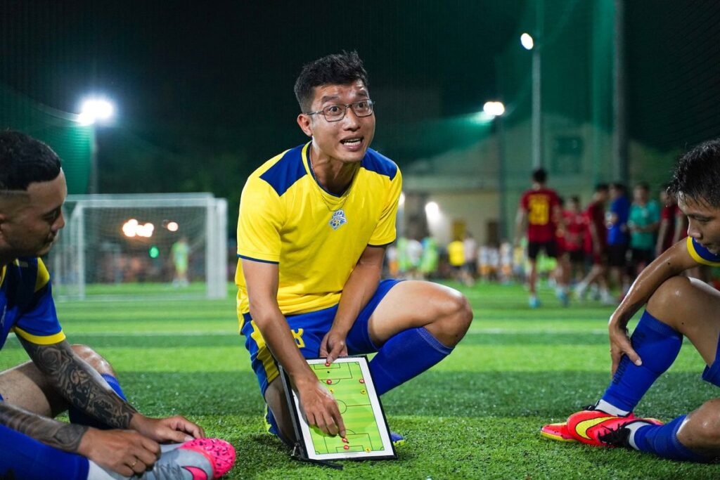 作戦ボードで戦術を確認するサッカー選手たち