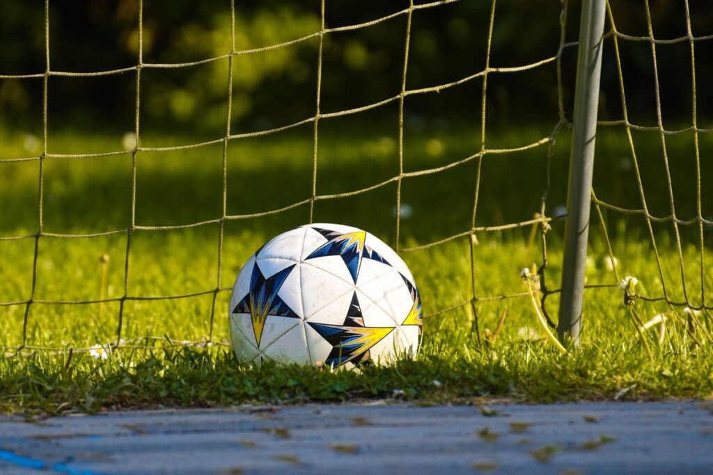 ゴールネット前の芝生に置かれたサッカーボール