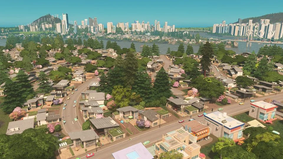 木々に囲まれた住宅街と、遠くに高層ビルが並ぶCities: Skylinesのゲーム画面