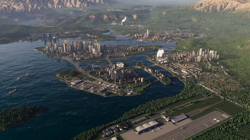 湾に面した街と空港を空から見たCities: Skylines IIのゲーム画面